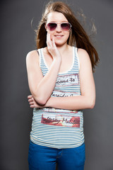 Pretty brunette teenage girl with sunglasses. Studio shot.