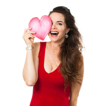 Laughing woman holding a love heart over her eye.