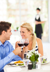 happy young couple eating out in restaurant