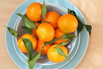 Ripe clementines on the blue, pastel plate