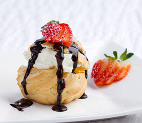 Choux cream snack topping with strawberry on dish