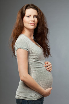 Young expecting mother with long dark hair.