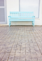 Blue wooden chair at the sidewalk.