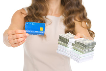 Closeup on woman giving credit card and money packs