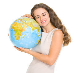 Happy young woman hugging globe