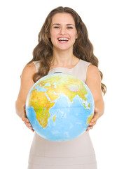 Happy young woman giving globe