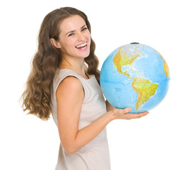 Smiling young woman holding globe