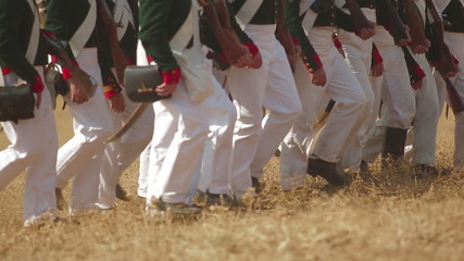 Troops marching along a field during a battle reenactment