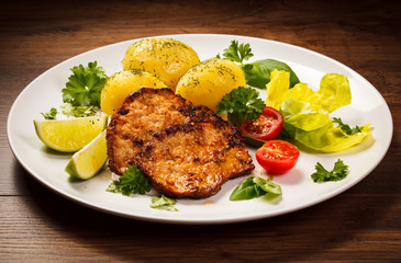 Grilled steaks, boiled potatoes and vegetables