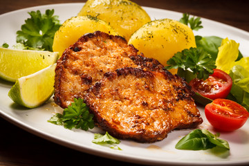 Grilled steaks, boiled potatoes and vegetables