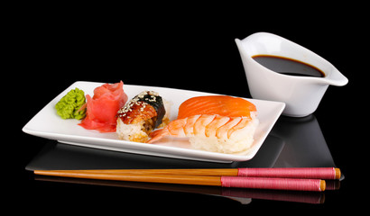 delicious sushi served on plate isolated on black