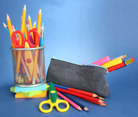 pencil box with school equipment on blue background