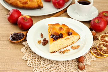 slice of tasty homemade pie with jam and apples and cup of