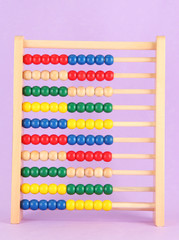 Bright wooden toy abacus, on purple background