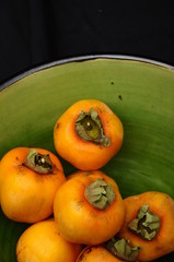 Kakis in a green bowl