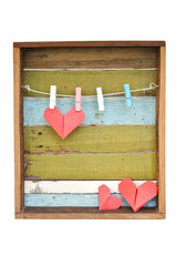 Paper heart hanging on the clothesline. On old wood background.