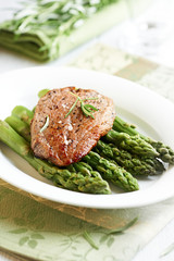 Beef steak on green asparagus