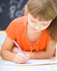 Naklejka na ściany i meble Dziewczynka jest pisanie za pomocą długopisu