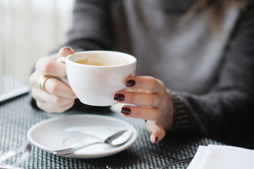 Woman's hands holding cup of coffee