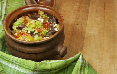 Meat and vegetables with sour cream and green celery  in a pot