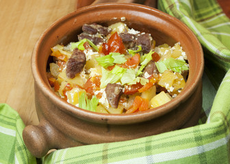 Meat and vegetables with sour cream and green celery  in a pot