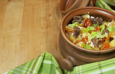 Meat and vegetables with sour cream and green celery  in a pot