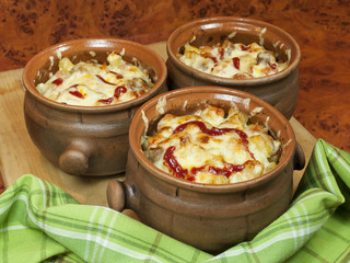 Meat and vegetables with cheese and ketchup  in pots