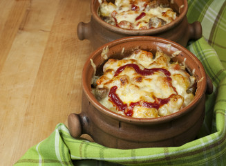 Meat and vegetables with cheese and ketchup  in pots