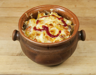 Meat and vegetables with cheese and ketchup  in a pot