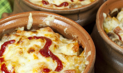 Meat and vegetables with cheese and ketchup  in pots