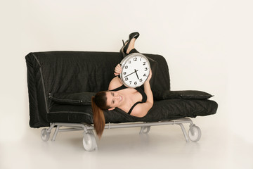 Mädchen auf der Couch mit Uhr