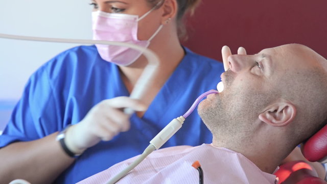 patient receiving details from his dentist about dental molds