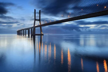 Foto op Plexiglas Vasco da Gamabrug Dageraad op de verlichte brug