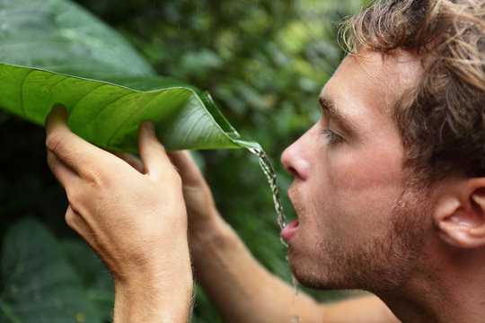 Survival - man drinking from leaf in jungle