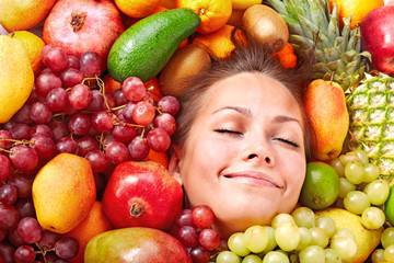 Happy girl in group of fruit.