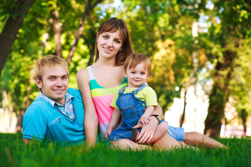 Naklejka na ściany i meble baby with parents in a beautiful summer park