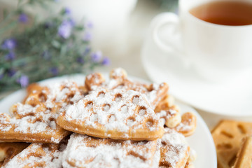 waffles with powdered sugar and a cup of tea