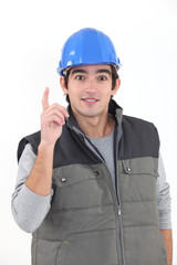 A young construction worker raising his finger.