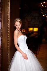 Fototapeta premium sexy blond bride in white wedding dress in interior