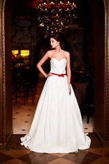Naklejka premium sexy happy bride in white wedding dress in interior