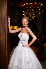 Naklejka premium sexy blond bride in white wedding dress in interior