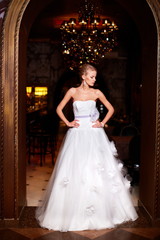 Fototapeta premium sexy blond bride in white wedding dress in interior