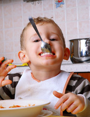 Gracioso niño comiendo en la cocina,alimentación de un niño.