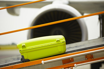 The baggage on the conveyor belt to the airplane.