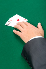 Hand with aces on the green table