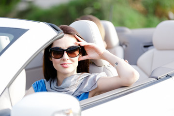 Portrait of dreamy woman wearing sunglasses in the cabriolet