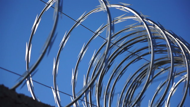 Razor Wire Close Up Pan Against a Blue Sky
