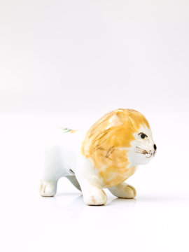 A ceramic lion doll isolated on white background in profile view