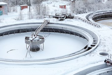 Covered with snow round settlers in sewerage treatment plant