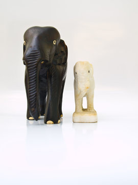 A wooden and a marble elephant doll s isolated on white backgrou